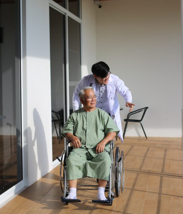 caretaker-helping-senior-man-with-disability-at-checkup-visit.jpg