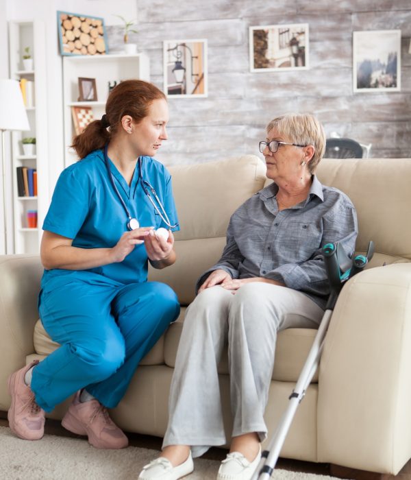 female-nurse-sitting-on-couch-with-senior-woman.jpg